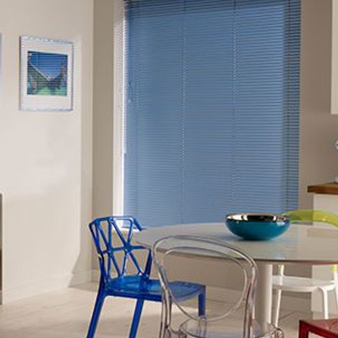 dining area with colourful dining chairs and blue venetian blinds