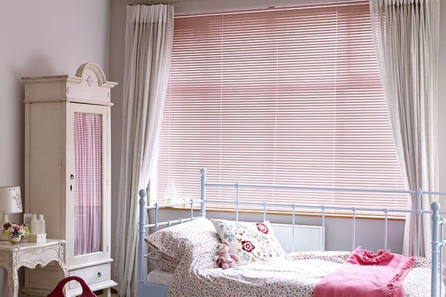 childs bedroom with pink venetian blinds and floral decor