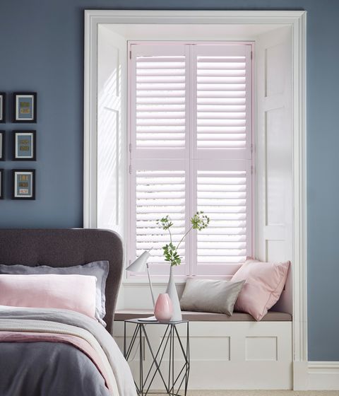 Pink tier on tier shutters on a window in a bedroom