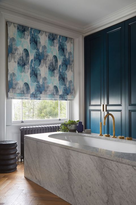 Bright blue blinds with sphere patterns in a luxuriously decorated bathroom window 