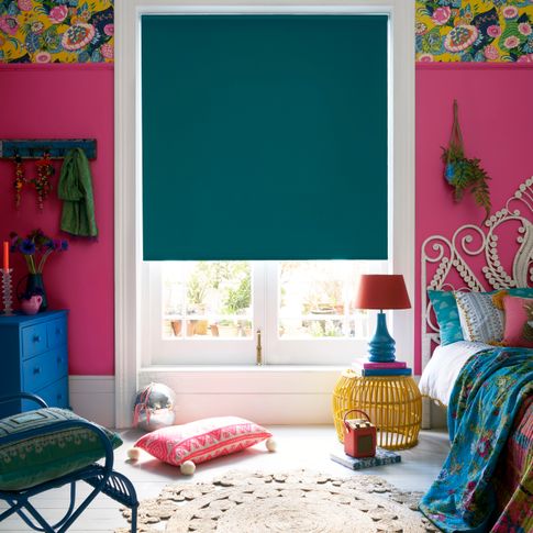 Colourful eccentric bedroom with different patterns and textures and a Plain blue roller blind