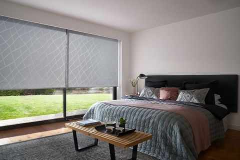 A Grey Patterned Roller Blind in Silver in a one bed Bedroom