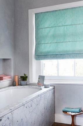 Bathroom with marble effect and light blue roman blind
