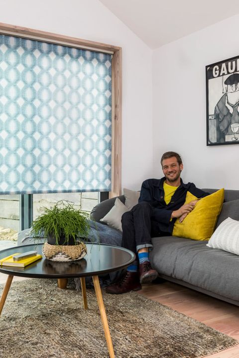 Charlie Luxton sat in a Living Room with blue roller blinds 