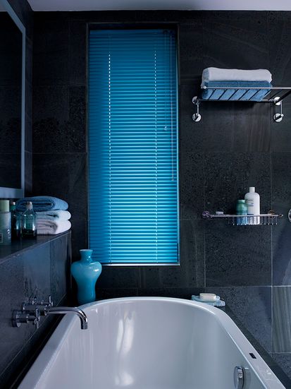 Dark tiled bathroom with midnight blue venetian blinds