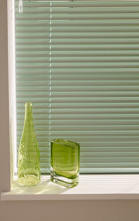 A close up of Venetian blinds in green
