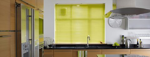 A bright green Venetian blind in a wooden kitchen