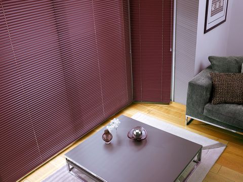A close up of purple Venetian blinds in a window