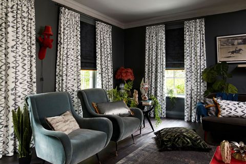 Dark, edgy living room with various textures and prints and dark grey roman blinds