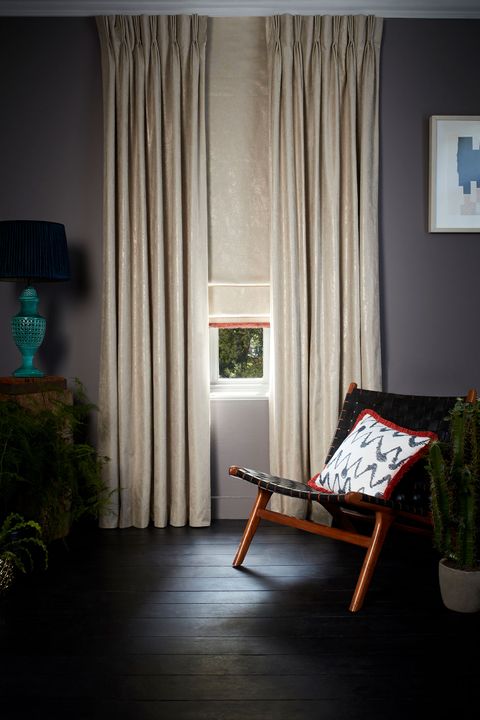 Dark and moody room decorated with Abigail Ahern Lucien Dust Curtains and matching Roman Blinds with a Colette Amour Fringing and a pattern Cushion in Wolfe Smoulder fabric