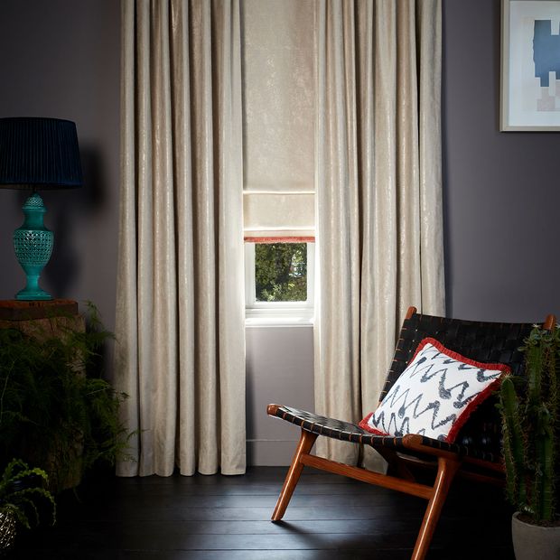 Dark and moody room decorated with Abigail Ahern Lucien Dust Curtains and matching Roman Blinds with a Colette Amour Fringing and a pattern Cushion in Wolfe Smoulder fabric