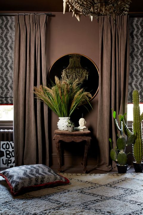 roman blinds with a zig zag pattern in black and white are paired with brown curtains in a room decorated with earthy tones