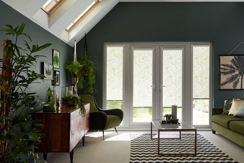 Dark tropical design living room with french doors dressed with green perfect fit blinds