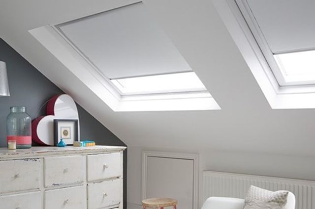 Loft bedroom with skylight windows and Acacia White roller blinds