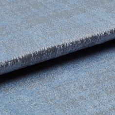 Folded grey coloured fabric layered with light blue in a textured appearance