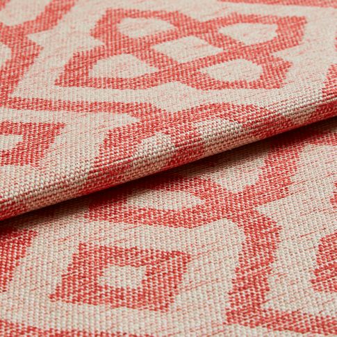 Cream coloured fabric featuring a repeating geometric pattern in a light red colour