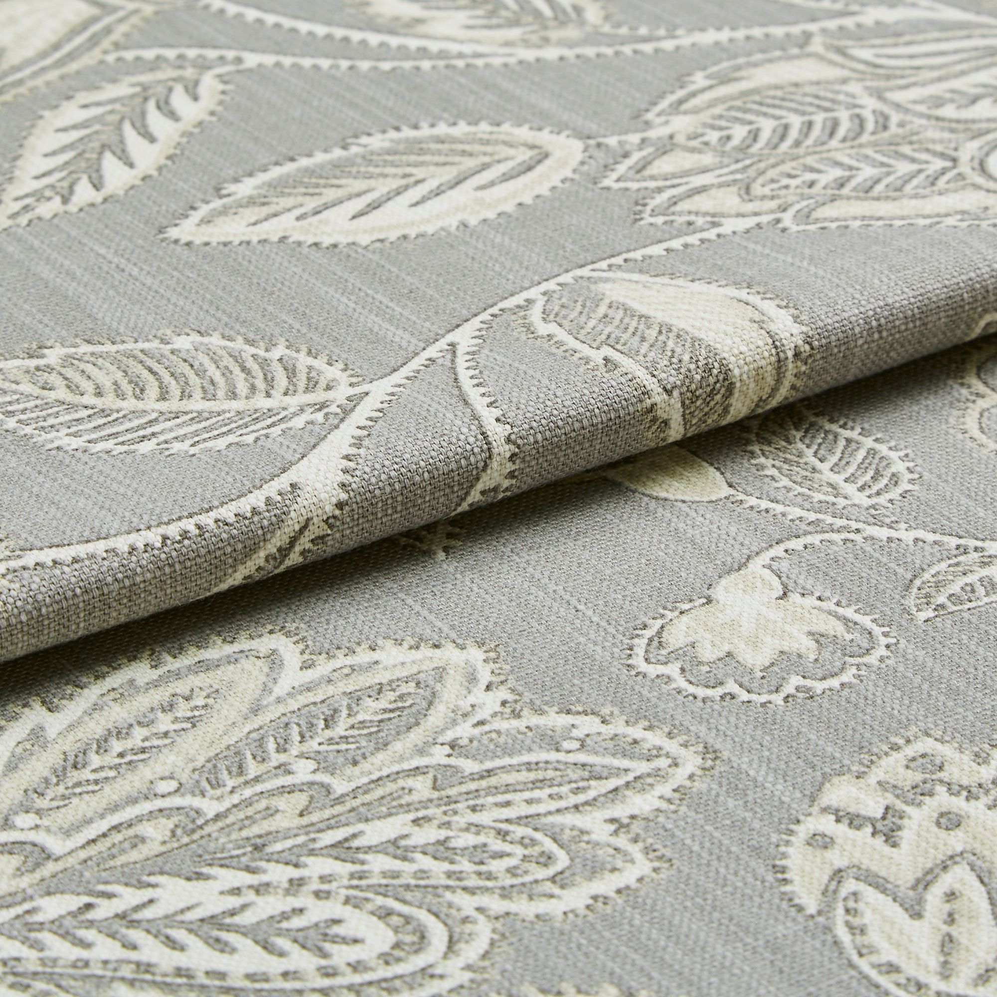 Grey coloured roman blind fabric which has an intricate leaf and stem design woven into the material in a white colour 