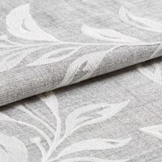 Light grey fabric with a leaf pattern in white that continously repeats
