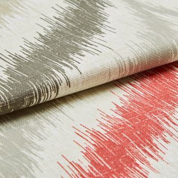 White fabric patterned with lines of grey, red and beige in a repeating design