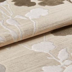 Beige colour fabric with a floral design in white and brown that repeats across the material