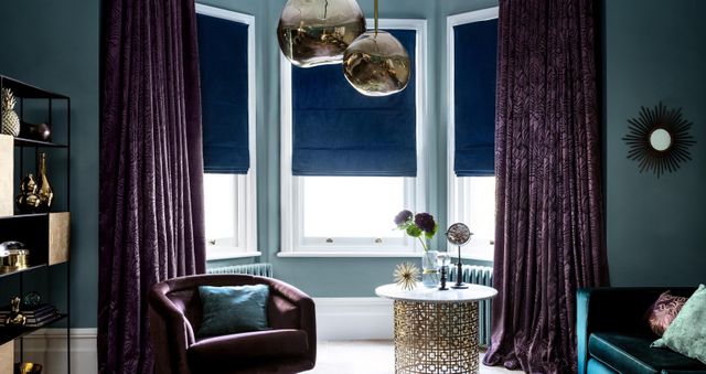 Living room with Broadleigh Aubergine curtains and Radiance Midnight Roman blinds at the window
