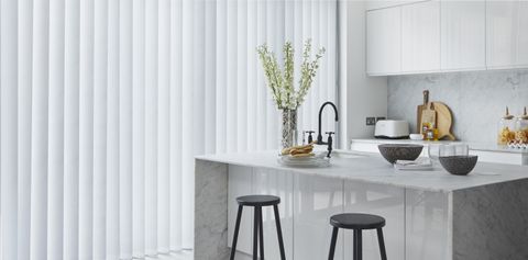Modern kitchen with island and full length white vertical blinds
