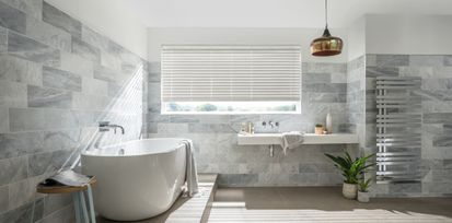 Large bright bathroom with matching grey wooden blinds slightly open to let in light