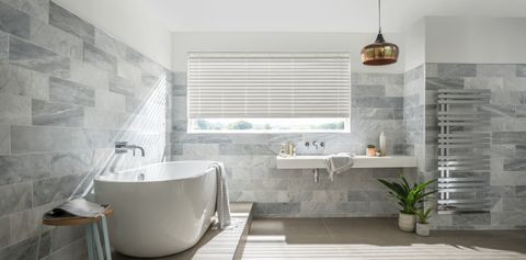 Large bright bathroom with matching grey wooden blinds slightly open to let in light