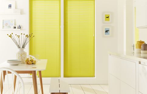 White open plan kitchen diner with contrast yellow venetian blinds