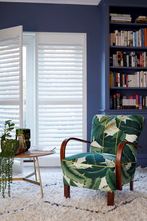 Windows dressed with full height white shutters in living room