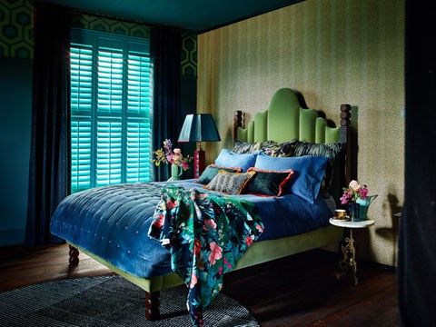 Dark and moody bedroom design with luxurious dark blue velvet curtains