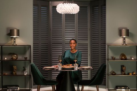 Image of woman smiling at dining table from Hillarys advert