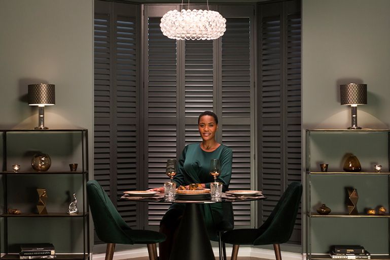 Image of woman smiling at dining table from Hillarys advert