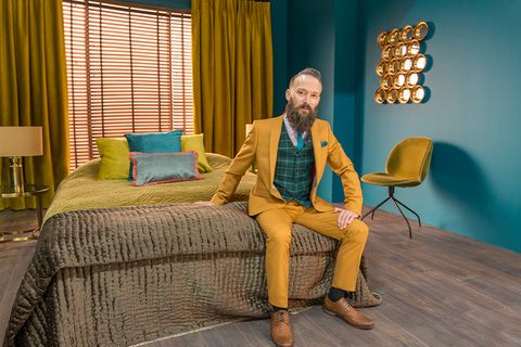 Man in mustard suit sitting on bed from Hillarys advert