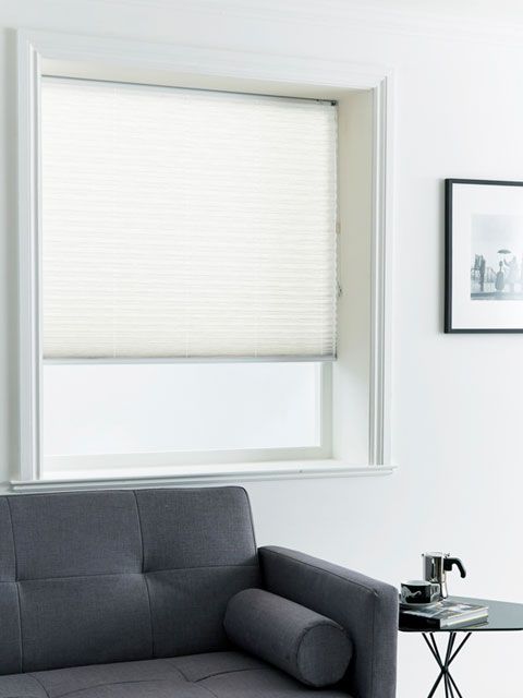 Pleated white blinds hanging in a living room