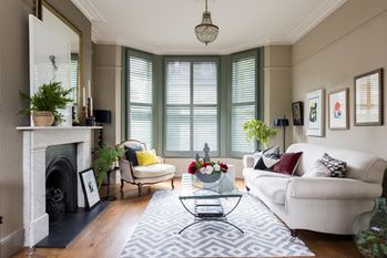 Living room with custom colour shutters in bay window
