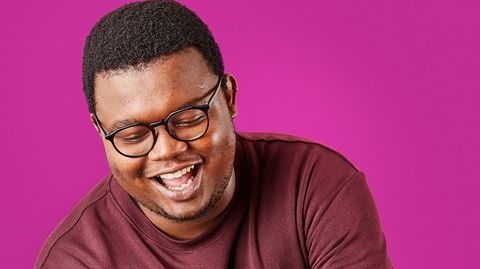 A photo of someone laughing against a bright purple background