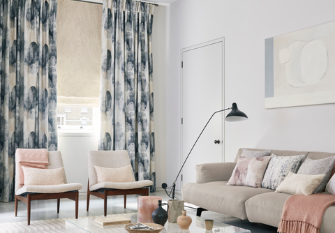 Relaxed living room with fade-out print curtains and cream Roman blinds