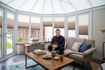 Architect and TV presenter George Clarke sitting in conservatory fitted with Hillarys blinds
