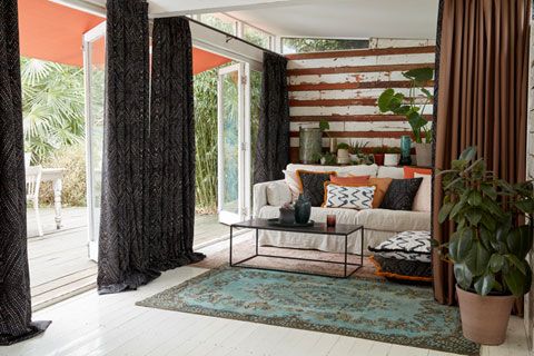 Cosy arden room with sofa and full length blackout curtains from the Abigail Ahern collection