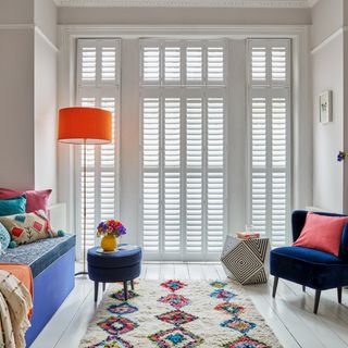 Living room with full height shutters at french doors