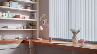 Off-white Vertical blinds in a home office. The blinds are above an oak desk