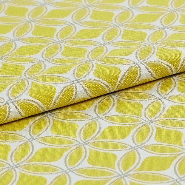 white fabric decorated in yellow with a geometric design that repeats across the material