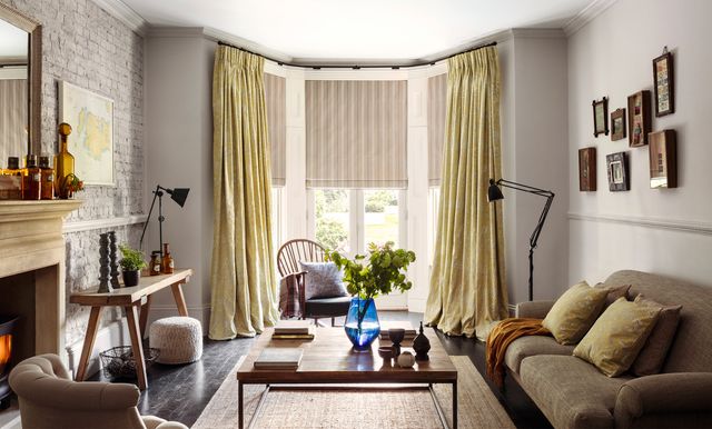 yellow curtains matched with beige roman blinds on a door window in a living room decorated in white