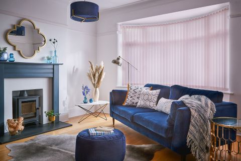 Modern luxe living room with royal blue decor and pale pink vertical blinds