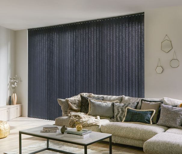 Modern luxe living room with plush cushions with gold accents and charcoal black vertical blinds