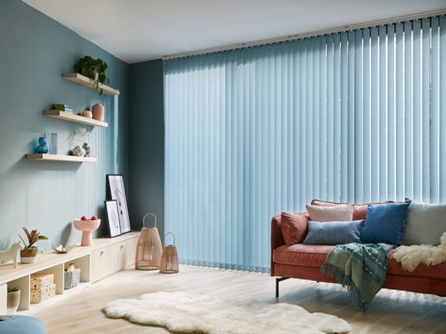 Fletcher Blue Vertical blind in a living room with wooden floors and blue walls