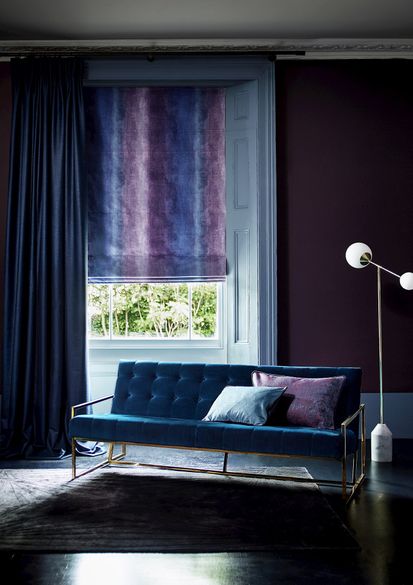 Close up of living room window with ombre velvet Roman blind and blue curtains