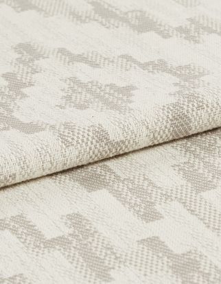 Cream coloured fabric with grey highlights that are scattered in a repeating pattern across the whole fabric