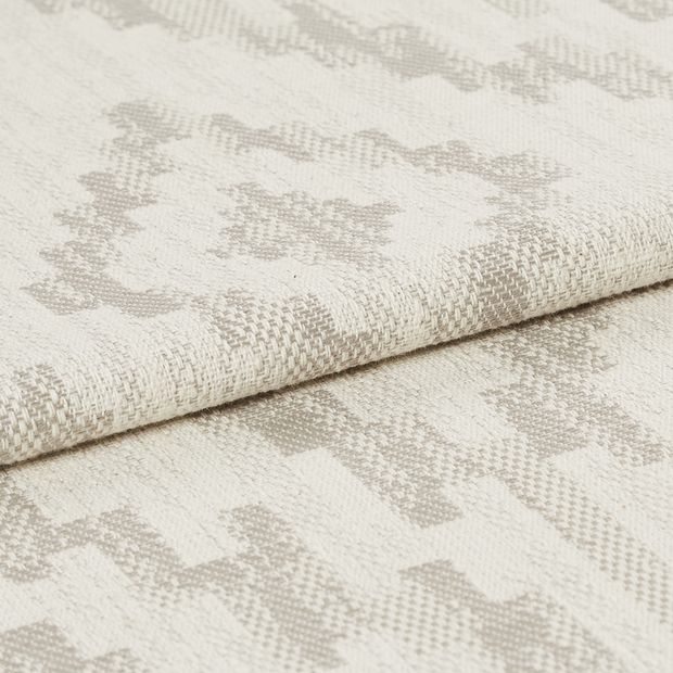 Cream coloured fabric with grey highlights that are scattered in a repeating pattern across the whole fabric